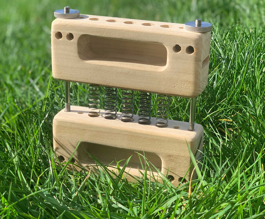 FingerFlex spring-powered portable hangboard shown outdoors — stackable spring resistance finger training tool for climbers